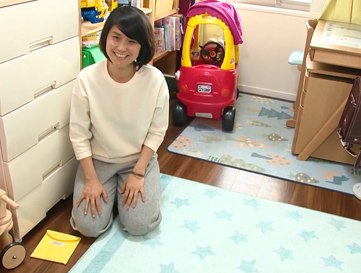 カーペットの横にダニ捕りロボを置いている女性