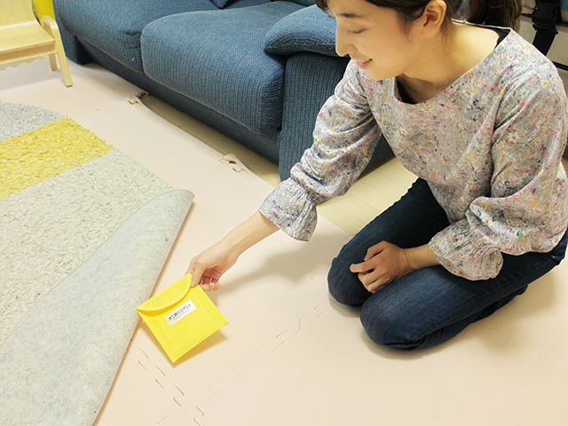 カーペットの下にダニ捕りロボを設置している写真