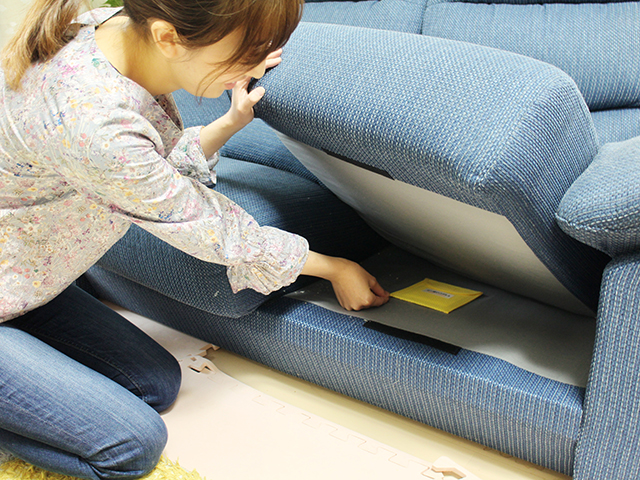 ソファの下にダニ捕りロボを設置している写真